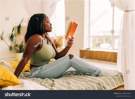 beautiful woman reading book indoors cozy stock photo