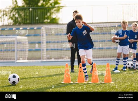 Group Of School Boys At Soccer Training Session With School Coach