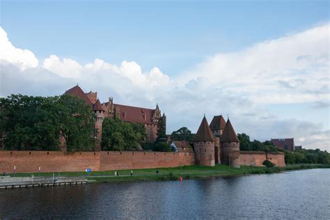 Beautiful View Of Malbork Castle Next To The River Fort And Buildings