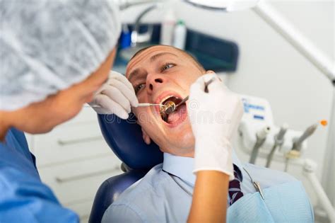 Female Dentist Examines The Oral Cavity Of Female Patient Dental