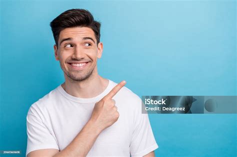 Photo Of Dreamy Tricky Guy Wear White Tshirt Looking Showing Finger Empty Space Isolated Blue