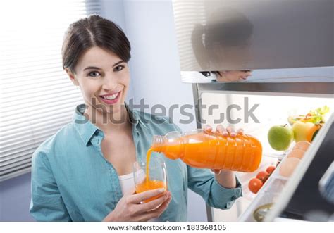 Cheerful Young Woman Pouring Fresh Fruit Stock Photo 183368105