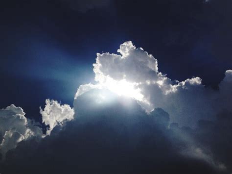 Premium Photo Low Angle View Of Sun Shining Through Clouds