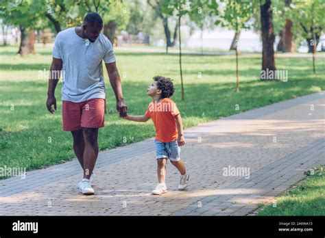 Happy African American Father And Son Holding Hands And Looking At Each