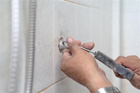 Asian man tries to fix and repair pipe shower in the old restroom ...