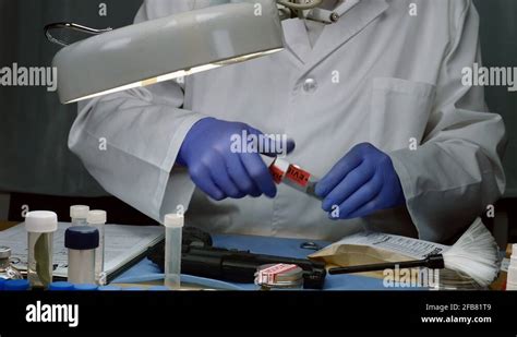 Scientific Police Examining And Making Photos Of A Bullet Cap In