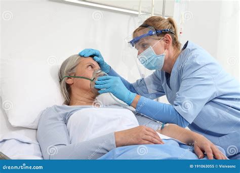 Nurse Puts Oxygen Mask On Elderly Woman Patient Lying In The Hospital