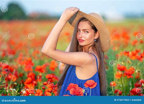 Portrait Of Young Woman With Long Hair And Straw Hat In Poppy Field In