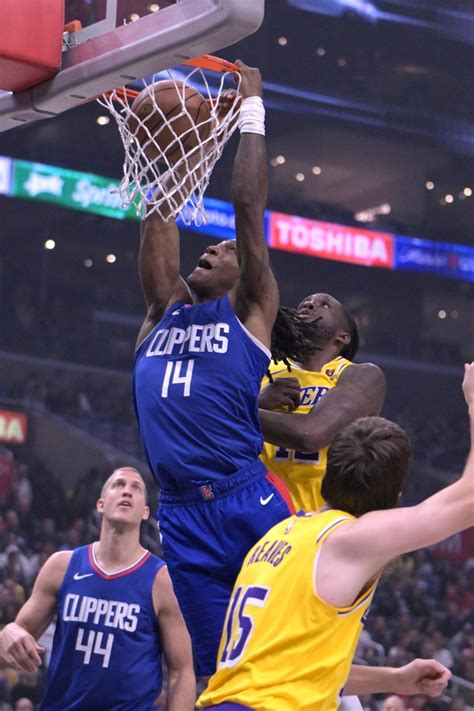 Los Angeles Clippers guard Terance Mann (14) drives past Los Angeles Lakers forward Taurean ...