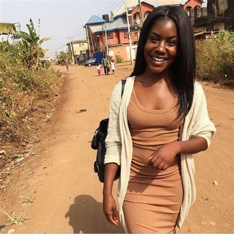 A Woman Is Walking Down The Street With Her Hand On Her Hip And Smiling