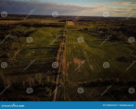 Aerial View Of Small River Flowing Through Green Marshy Riparian