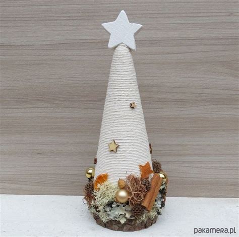 A Small White Christmas Tree On Top Of A Wooden Table Next To A Wood Wall