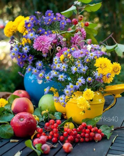 An Arrangement Of Flowers And Fruit On A Wooden Table In The Garden