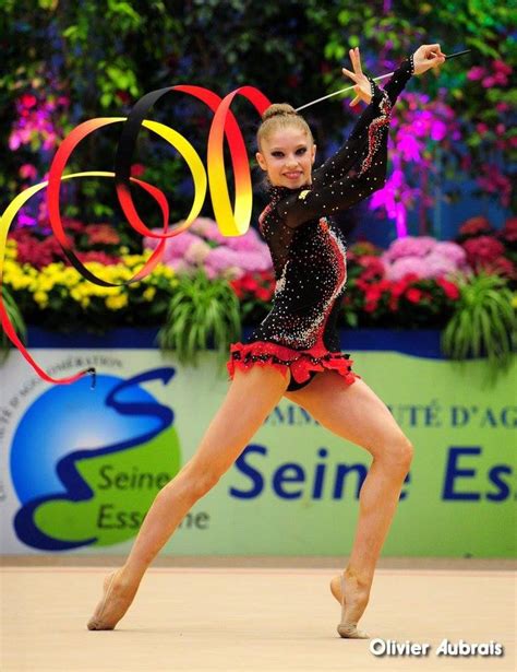 A Woman In A Black Leotard And Red Skirt Is Dancing With Streamers