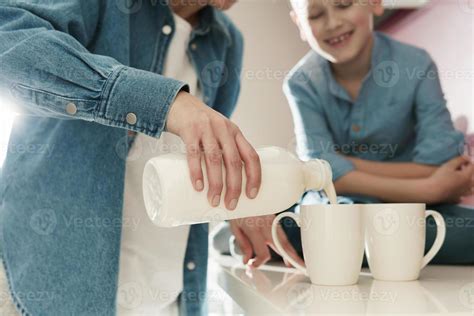 Mother And Her Cute Son Drinking Milk On The Kitchen Stock