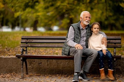 Grand père Passe Du Temps Avec Sa Petite fille Sur Un Banc Dans Le Parc