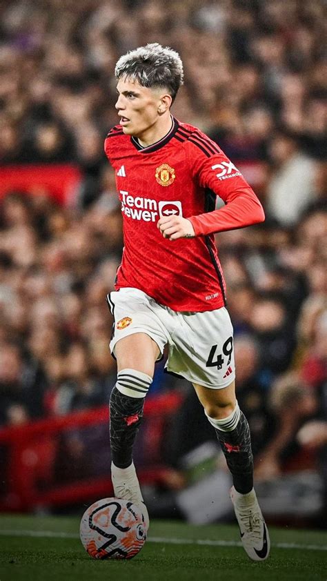 Man In Red Jersey Playing Soccer On Field With Crowd Watching From