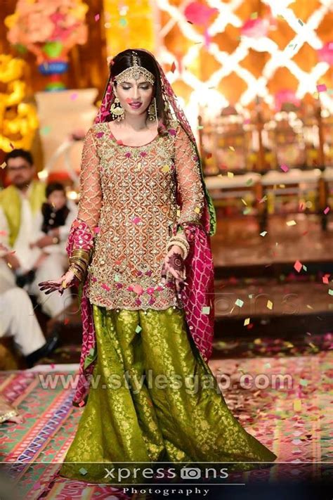 A Woman In A Green And Pink Lehenga