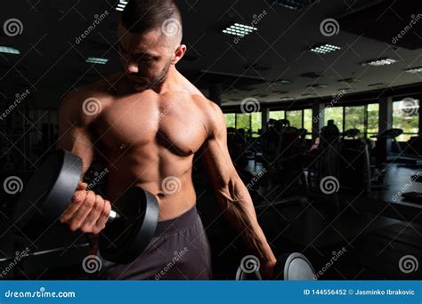 Culturista Que Ejercita El B Ceps Con Pesas De Gimnasia Foto De Archivo