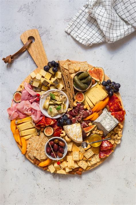 An Assortment Of Cheeses Crackers And Meats Arranged On A Platter