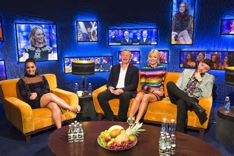 Three People Sitting On Couches In Front Of Television Screens With