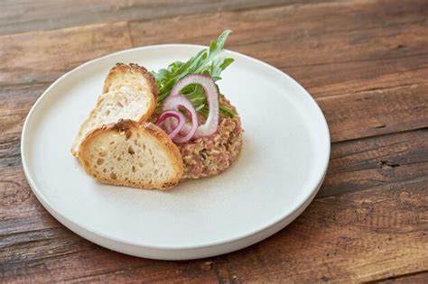 Angle élevé de portion de délicieux steak tartare avec croûtons servi