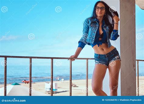 Seductive Brunette Girl Wearing Short Shorts And Jeans Jacket Posing