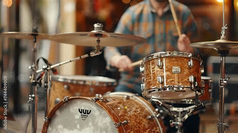 A Man Playing Drums The Drums Have A Classic Wood Finish And There