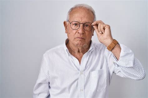 Senior Man With Grey Hair Holding Glasses With Hand Thinking Attitude