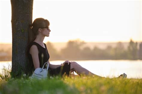 Premium Photo Lonely Woman Sitting Alone On Green Grass Lawn Leaning