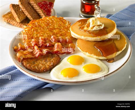 A Power Breakfast With Three Eggs Sausage Bacon Hash Browns Pancakes With Butter And Syrup