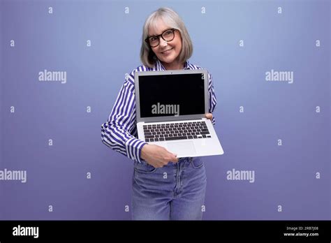 Smiling 60s Mature Woman With Gray Hair With Laptop Mockup On Bright
