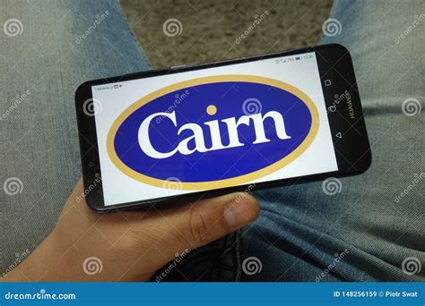 Man Holding Smartphone With Cairn Energy PLC Logo Editorial Stock Image