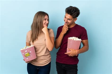 Premium Photo Couple Eating Popcorn While Watching A Movie On Purple