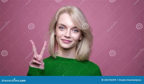 Smiling Caucasian Woman Showing Victory Sign On Pink Background Stock