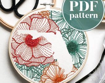 The Embroidery Pattern Is Being Displayed With Scissors And Thread