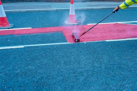 Premium Photo Road Workers Applying Hot Melt Traffic Resistant Paint For White Yellow And Red