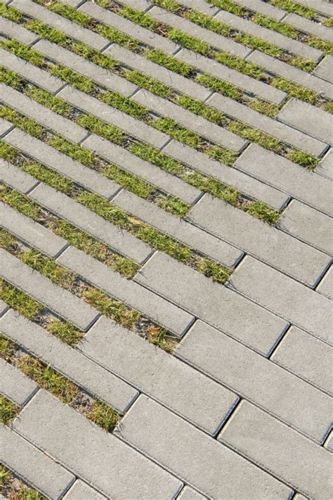 A Red Fire Hydrant Sitting On The Side Of A Brick Road Next To Grass