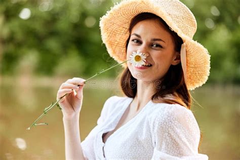 Retrato De Una Mujer Feliz En Un Sombrero De Mimbre Con Una Camomila En