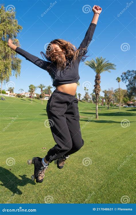 Young African American Women Wearing Roller Skates Jumps On Grass Stock