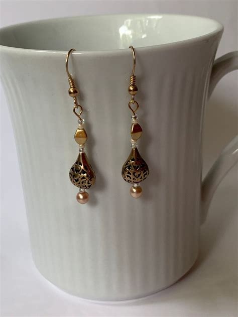 Bronze Open Weave Tear Drop Bead With Gold And Cream Accent Beads On