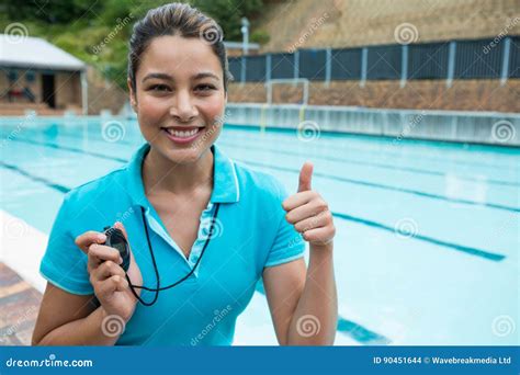 Portrait Of Swim Coach Holding Stopwatch And Showing Thumbs Up Near