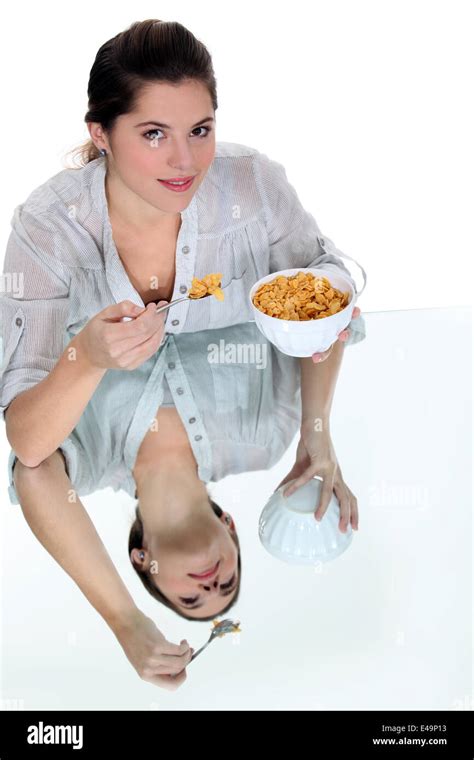 Woman eating bowl of cereal Stock Photo - Alamy