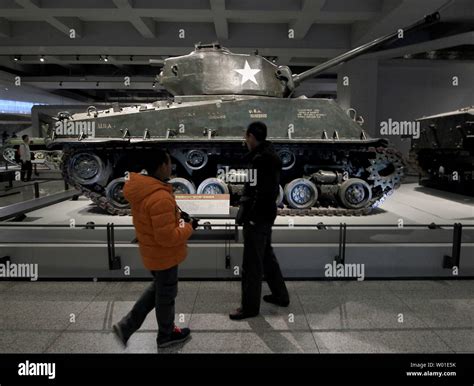 Chinese Visitors Look At A Us Sherman Tank On Display At The Military