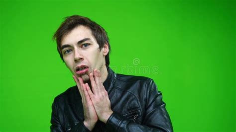 White Man In Leather Jacket Holding His Head In Panic Or Stress Over Green Screen Background