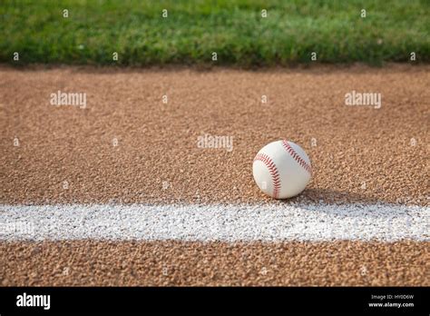 A Baseball Sits On A Base Path With Grass Infield Stock Photo Alamy