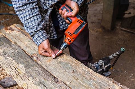 Carpenter está trabajando para perforar madera Foto Premium