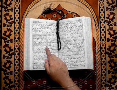 Image Of Muslim Woman Reading The Holy Quran Using The Finger The Holy