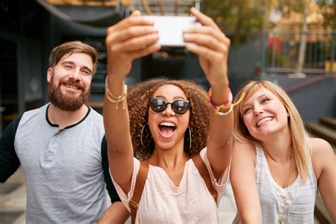 Group Of Smiling Friends Taking Selfie With Smart Phone | Brodsky ...