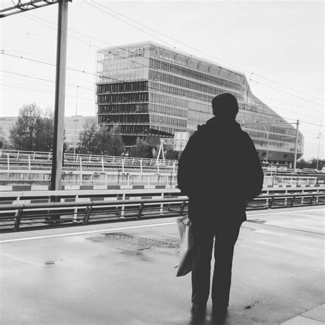 Premium Photo Rear View Of Man Standing On Platform Against Building